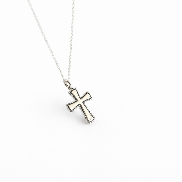 Silver cross pendant necklace on a white background